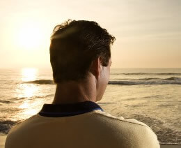 photo man on beach setting divorce goals while gazing at ocean